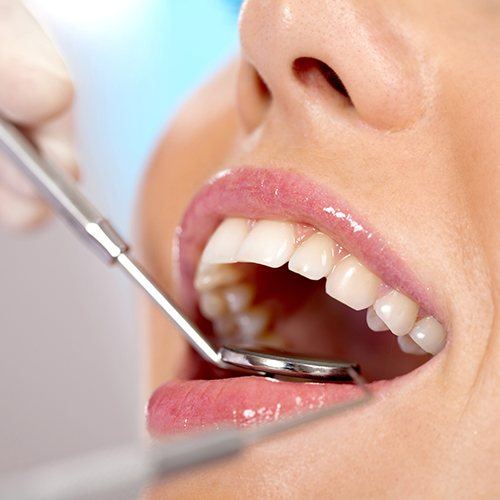 Dentist examining patient's smile after all ceramic dental restorations