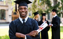 Man smiling in a cap and gown