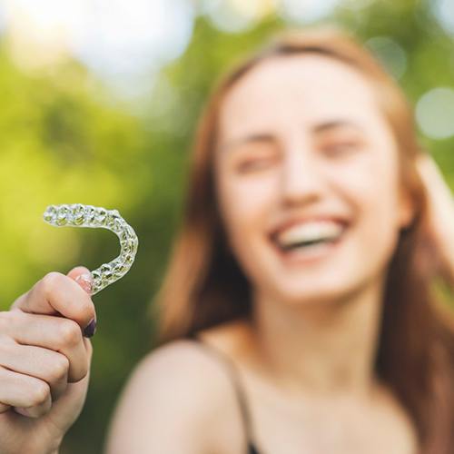 Young woman holding up aligner for ClearCorrect in Lacey, WA