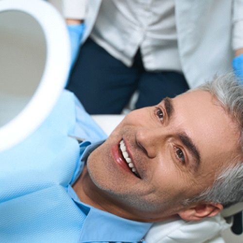 Patient admiring his new dental bridge in Lacey