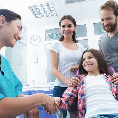 Child and parents talking to dentist during family dentistry visit