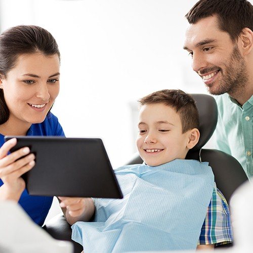 Father child and dental team member reviewing comprehensive dentistry plan