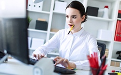Woman chewing pen while working at home