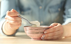 patient eating yogurt after getting dental implants in Lacey 