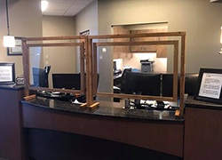 Clear barriers in front of dental office reception desk