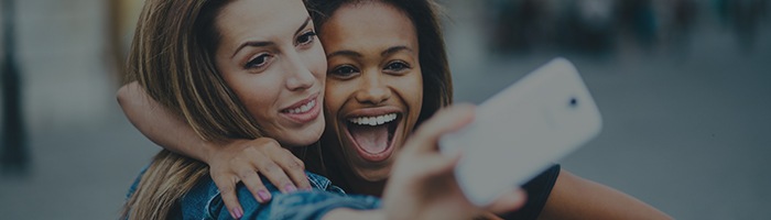 Two young women taking selfie outdoors