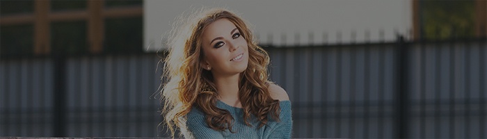 Woman with curly hair smiling outdoors