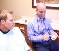 Lacey dentist showing model of the teeth to a patient