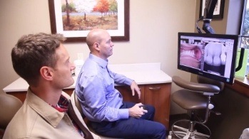 Lacey dentist looking at images of a patient's teeth on computer