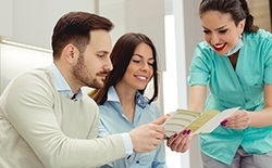 Team member giving dental patients insurance paperwork