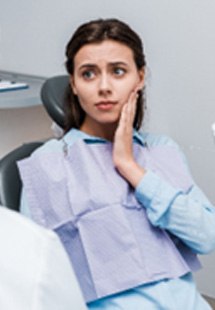 Woman with toothache talking to emergency dentist in Olympia