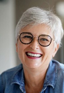 Mature woman in denim shirt smiling at home