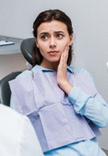 Woman with toothache talking to emergency dentist in Tumwater