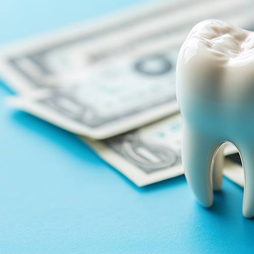 Money and artificial tooth on a table