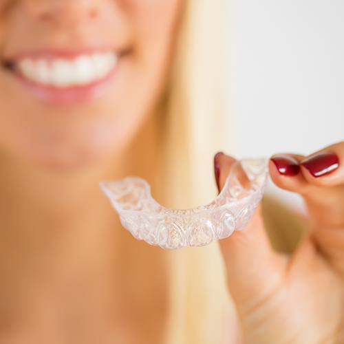 Patient placing SureSmile aligner tray