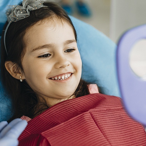 Little girl looking at smile after children's dental care