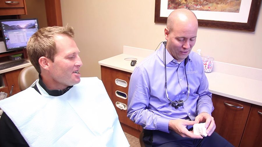 Lacey dentist showing model of the teeth to a patient