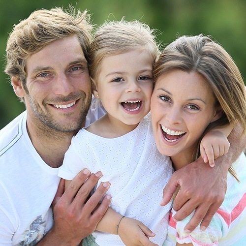 Mother father and child smiling together after family dentistry