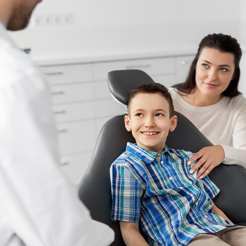 Child and mother talking to dentist during children's dental care visit