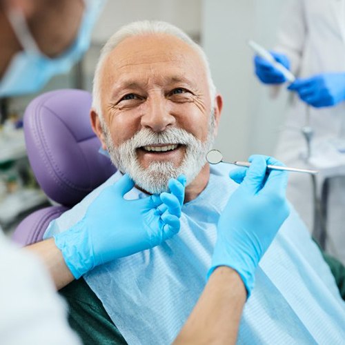 a patient smiling while visiting his dentist