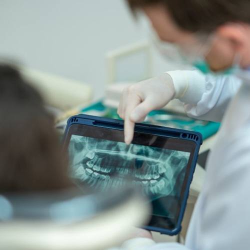 a dentist showing a patient an X-ray of their teeth