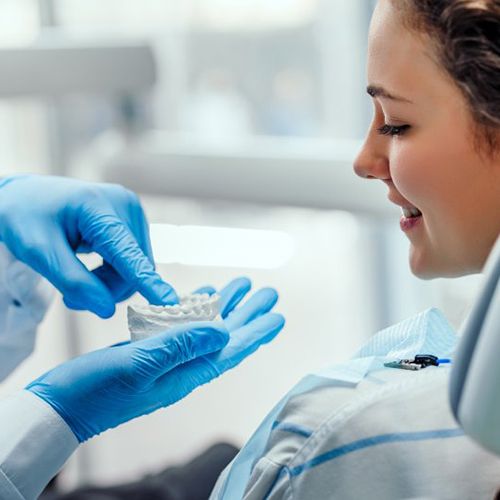 a patient being shown a model of teeth