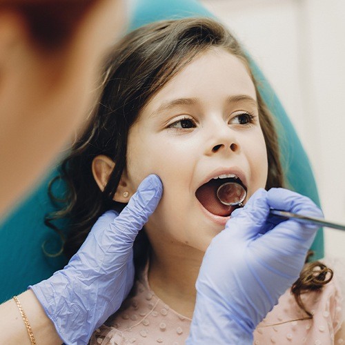 Dentist examining child's smile after dental sealants