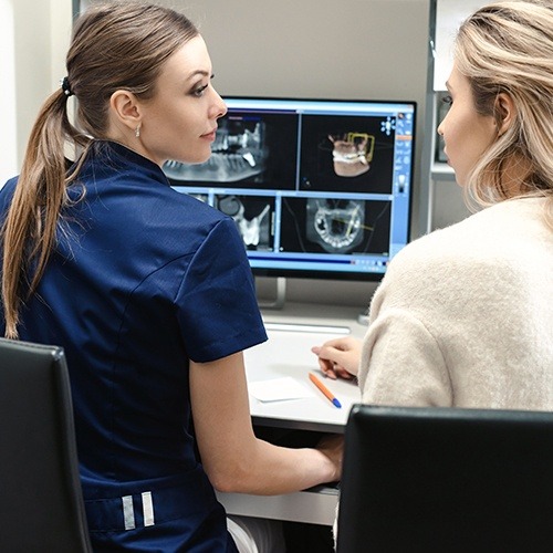 Dental team member looking at digital x-rays on computer screen