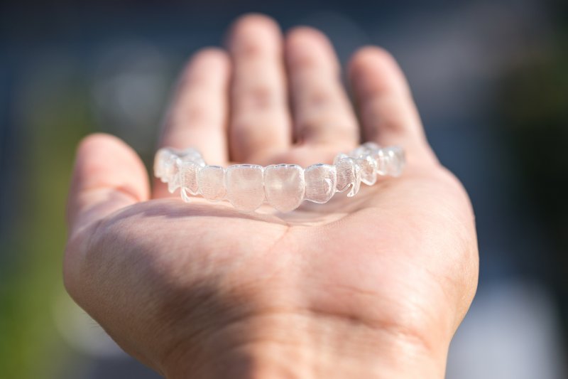 SureSmile aligner in the palm of a hand