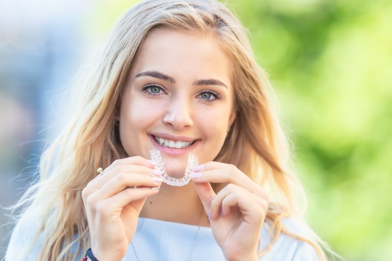 closeup of woman holding SureSmile aligner