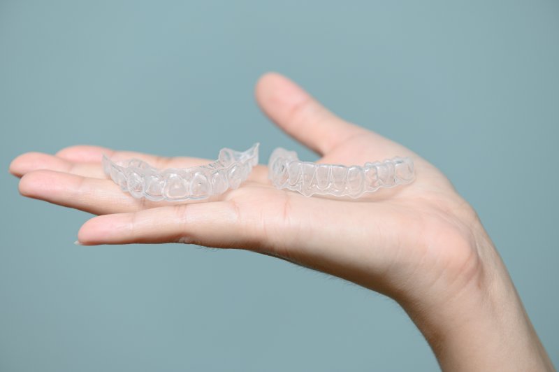 person holding clear aligners