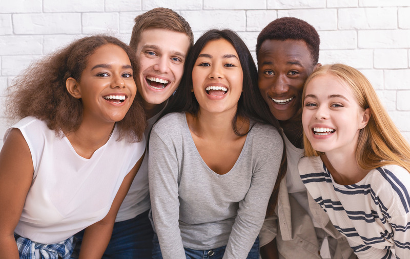 Teen dental implants patient smiling with friends