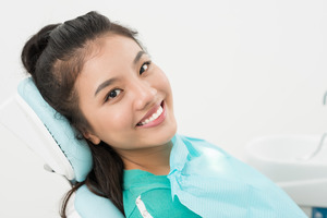 Patient sitting in dental chair and smiling