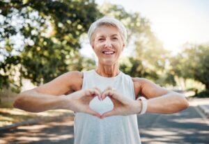Smiling senior woman making a heart shape with her hands