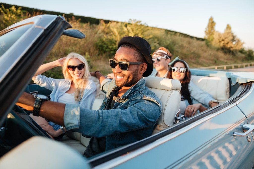 Group of friends smiling on a road trip