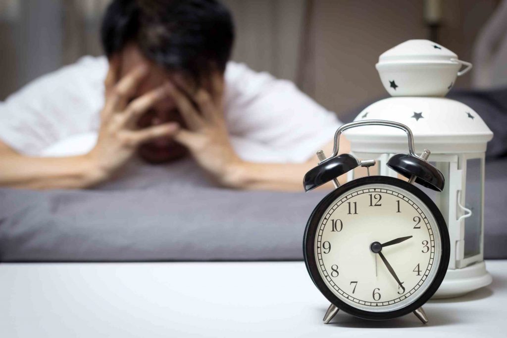 Frustrated man with his alarm clock ringing